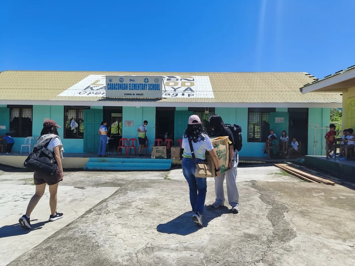 Volunteers carrying boxes of school supplies to the island school