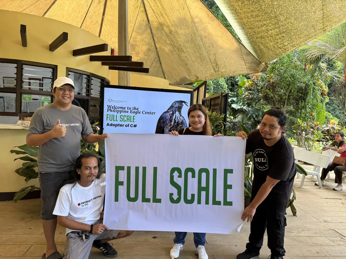Full Scale volunteers holding the company banner at the Philippine Eagle Center in Davao
