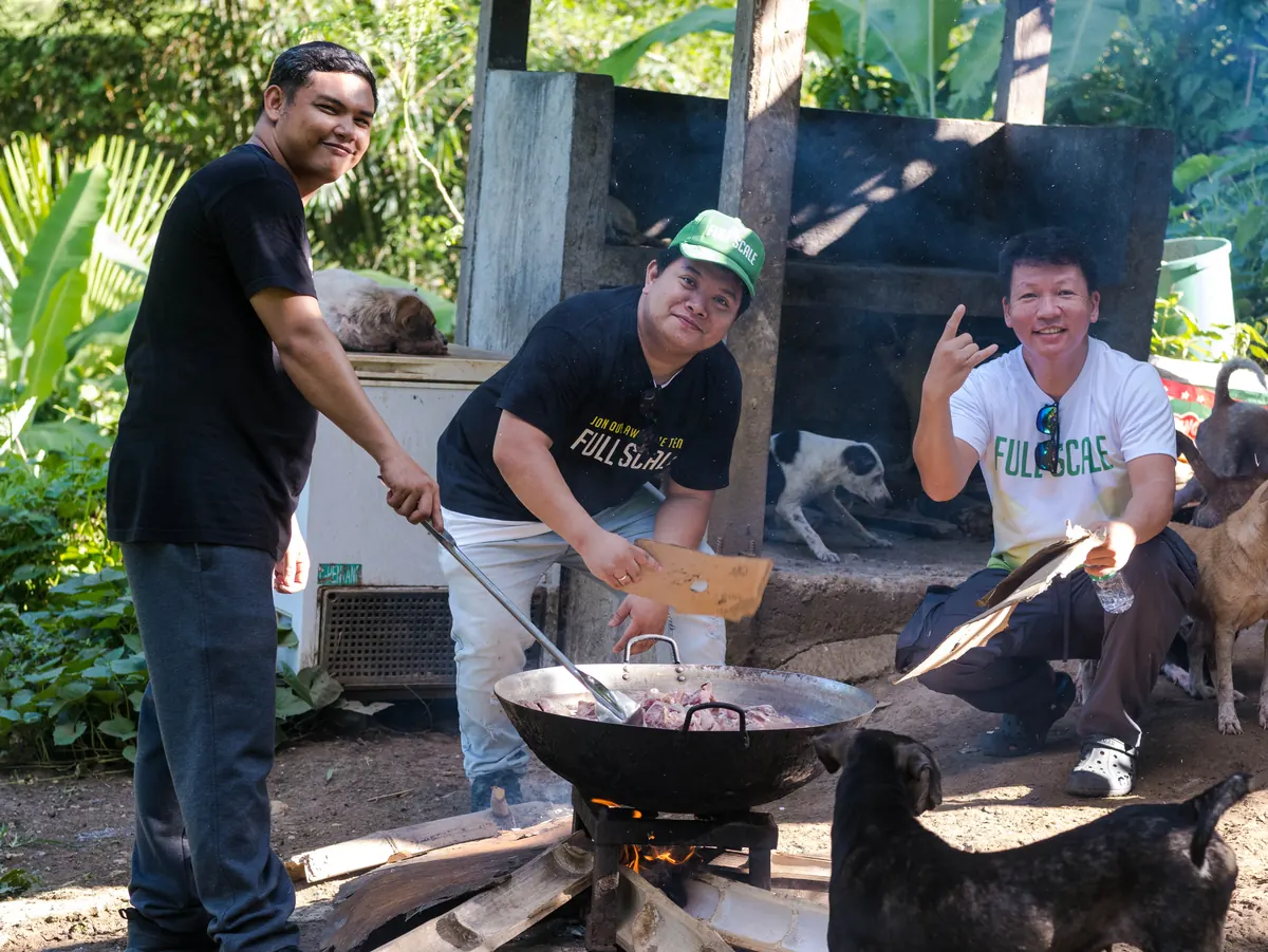 Full Scale volunteers cooking a large batch of food for rescued dogs at Island Rescue Organization